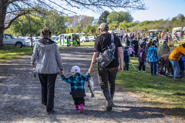 Three year old Sierra gets a helping hand with her salmon from dad Fletch, right, and great aunty Clare, left, at the Take A Kid Fishing Day.