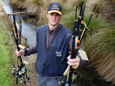 Photo 1 Fish Game Officer Hamish Stevens displays just two handfuls of the rods siezed from offending anglers over the past season 2